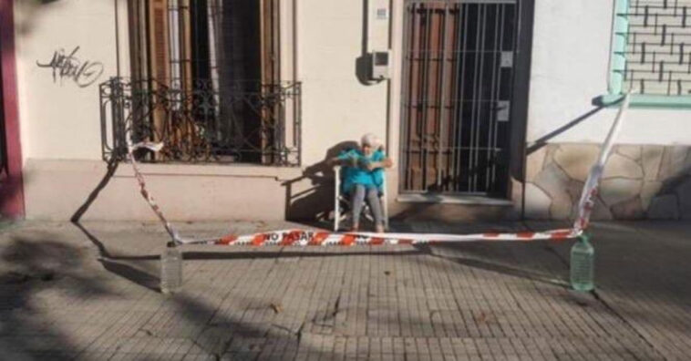 Idosa isola calçada para continuar tomando banho de sol de manhã sem risco de se contaminar