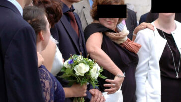 Mãe do noivo segura a mão do filho em fotos com a nora no casamento