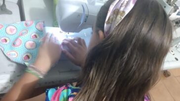 menina costura máscaras em projeto social