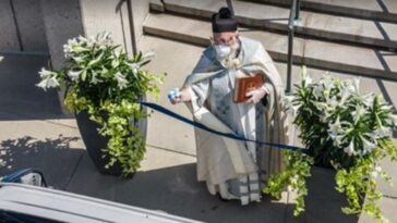 padre benze fiéis com pistola dágua